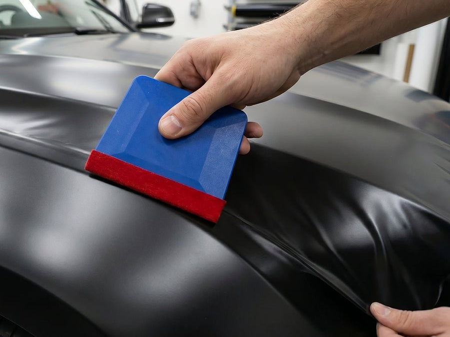 Hexis MARBLEU blue felt edge squeegee applying vinyl wrap on vehicle fender for scratch-free installation