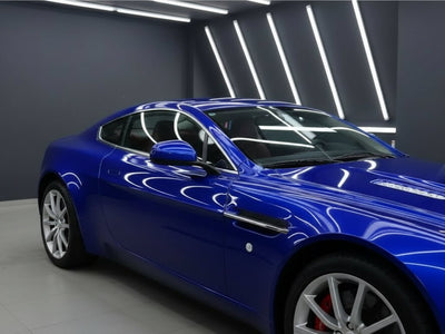 Aston Martin V8 Vantage wrapped in Hexis Gloss HX20000 Triton Blue restyling film HX20P005